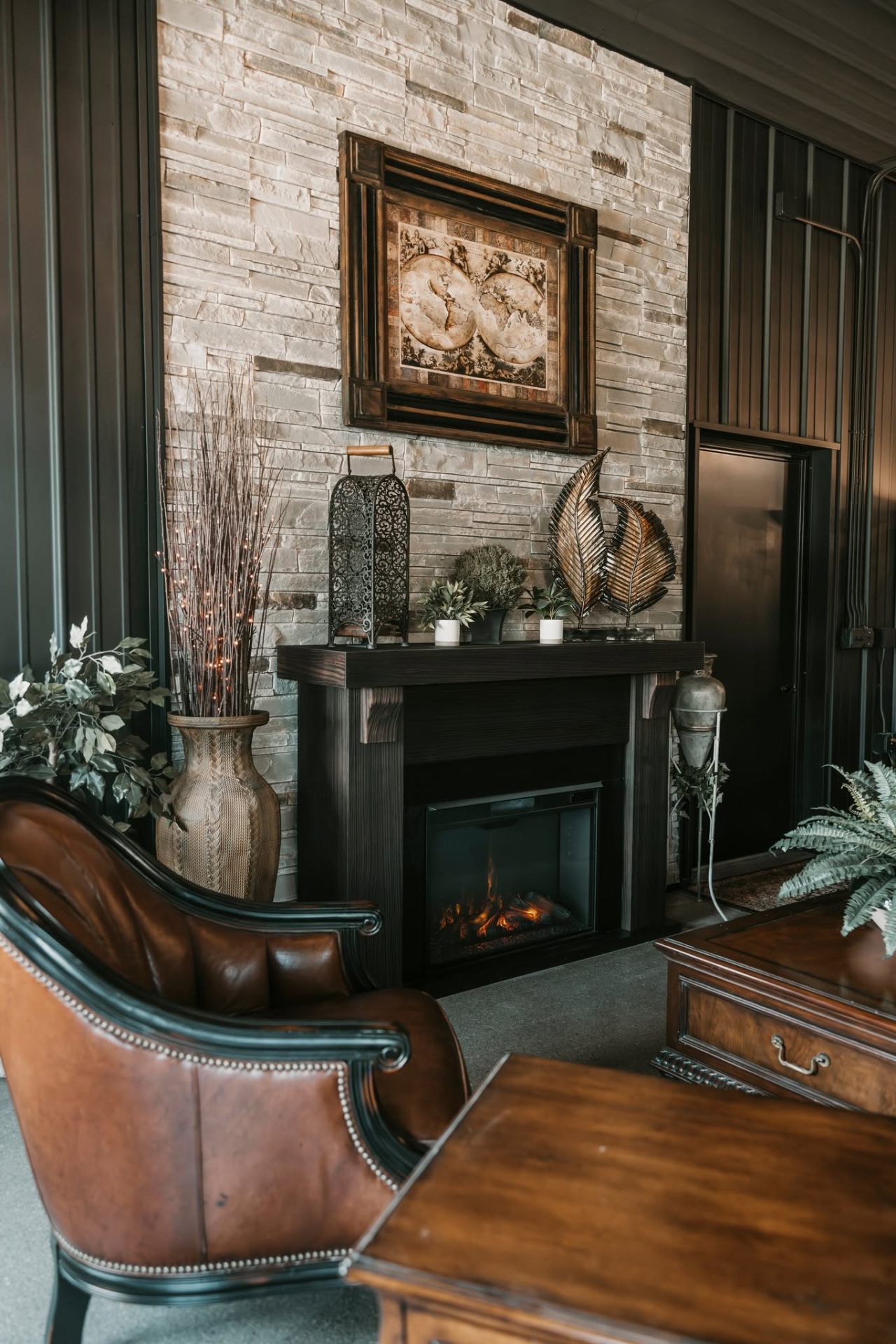 Second stone fireplace with leather chair and antique vase