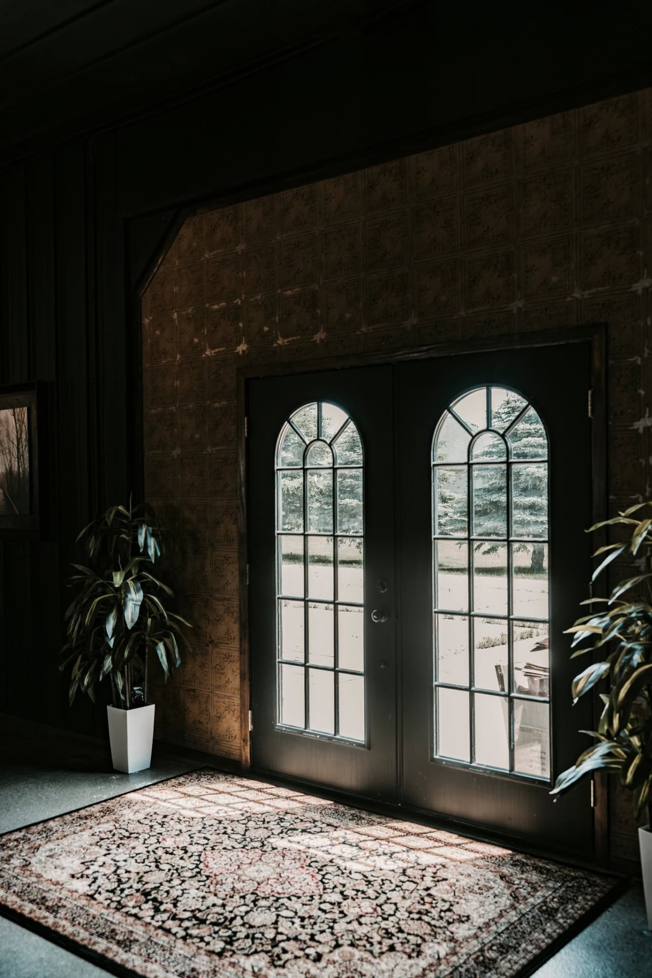 Arched glass entry doors and Persian rug in the foyer